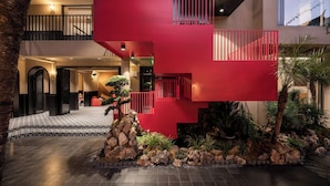 Ein modernes Interieur mit einer roten Treppe, Steinplattenboden und einem kleinen Steingarten.