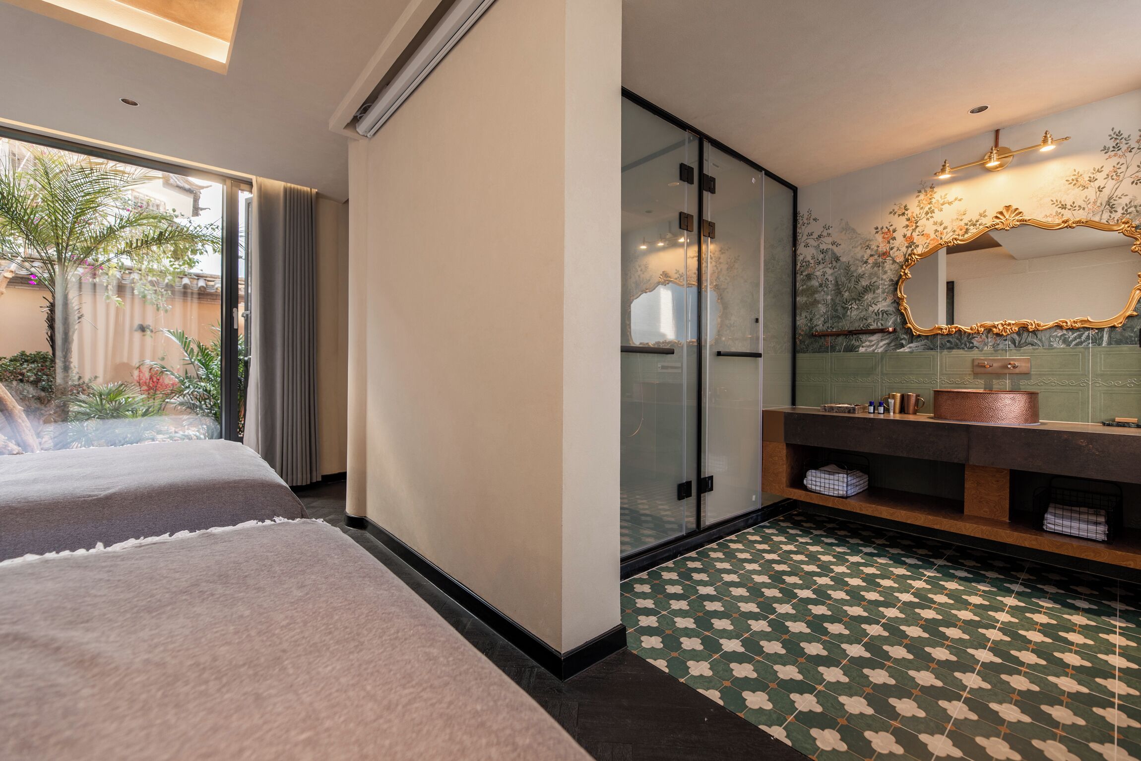 A hotel room with two beds, a glass shower enclosure, a vanity with a copper sink, and a patterned floor.