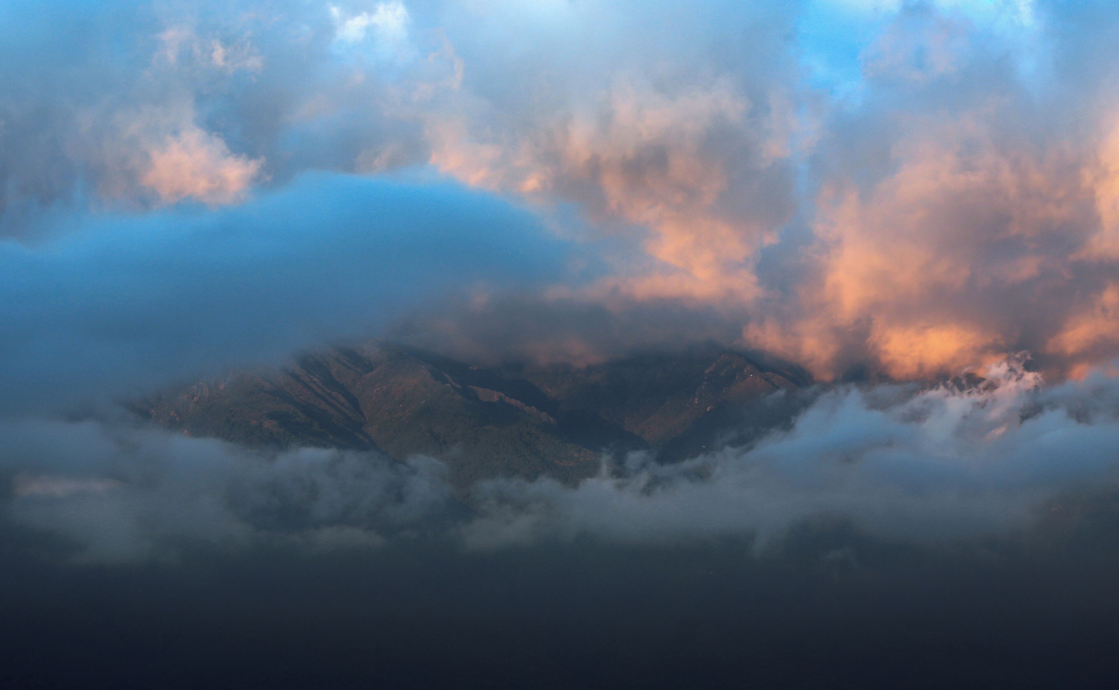 A mountain range partially obscured by clouds.