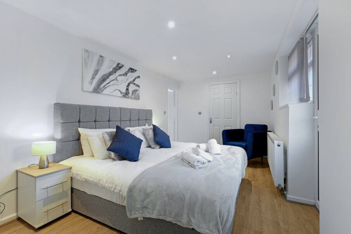 Una camera da letto moderna con un letto, un comodino e una sedia.
