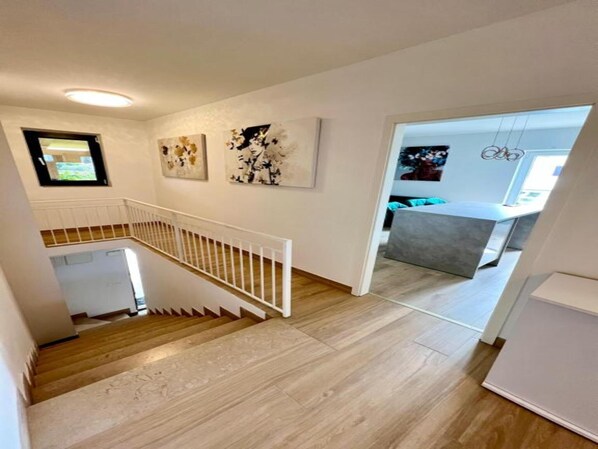 A staircase leading to a modern kitchen area with a dining table and chairs. - Apartments Kalinić (Janjina)