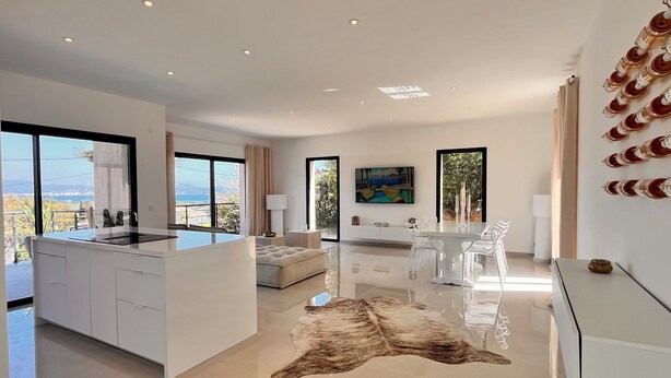 Una cocina moderna con una isla central, ventanas amplias y un comedor con vistas.