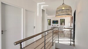 Un interior moderno con una escalera, una araña y un comedor.