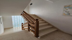 A staircase with wooden railings and beige steps leading to a landing. - Studio in Tribunj near Bristak Beach (Tribunj)