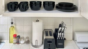 A kitchen with white shelves holding glassware and black bowls. - Resort Style Home near Beaches & Disneyland (Fountain Valley)