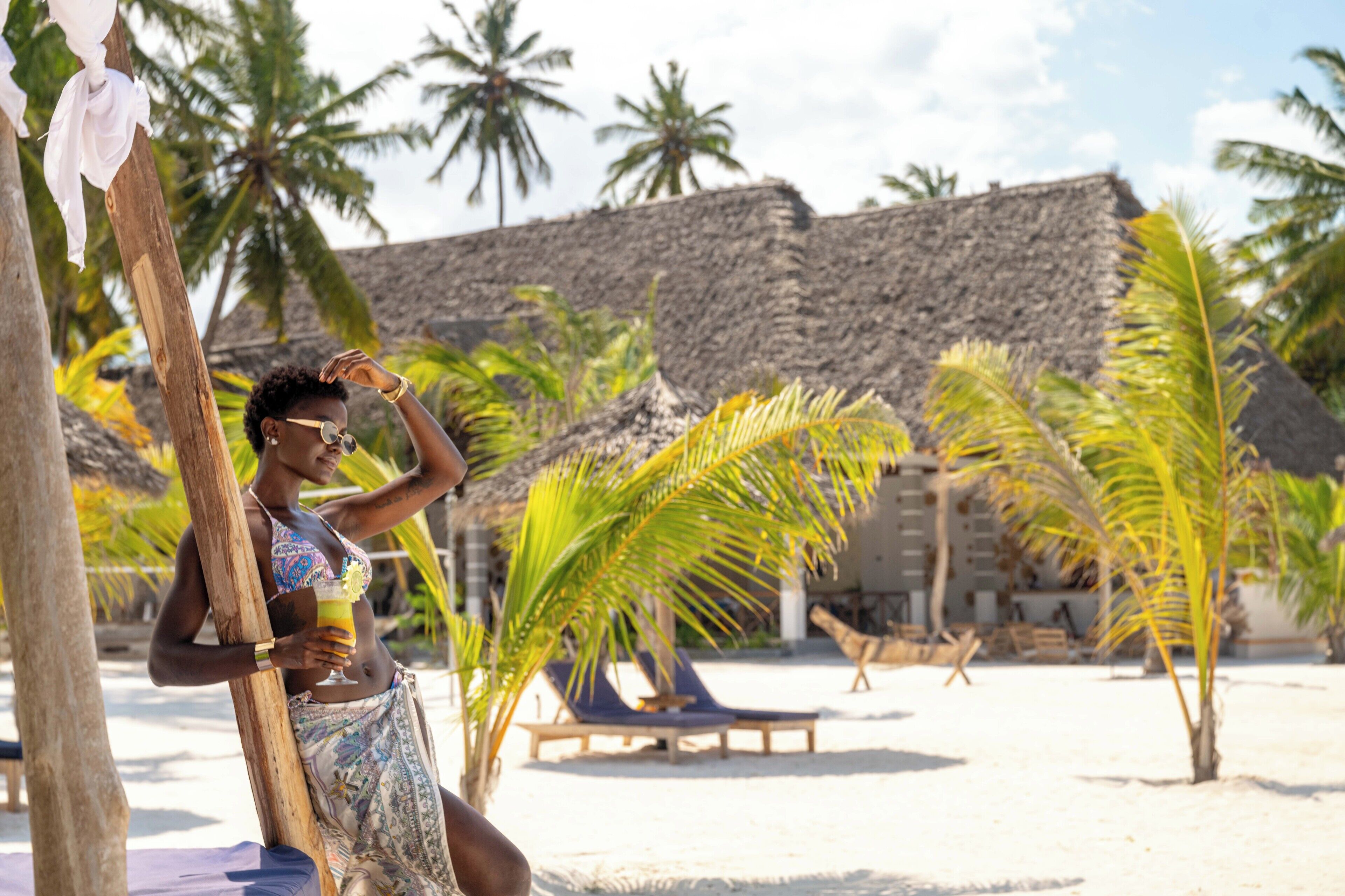 Privat strand, hvit sand, solsenger og parasoller