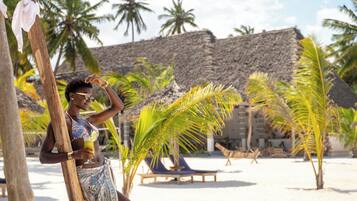 Privat strand, hvit sand, solsenger og parasoller