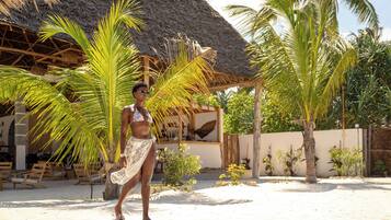 Privat strand, hvit sand, solsenger og parasoller