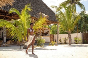 Praia particular, areia branca, espreguiçadeiras, guarda-sóis 