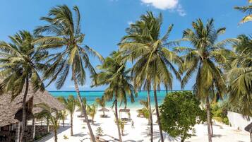 Privat strand, hvit sand, solsenger og parasoller