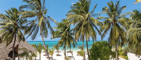 Plage privée, sable blanc, chaises longues, parasols