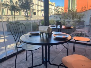 A dining area with a round table, chairs, and a small table with a chair. - TERRAZZA CARBONARA B&B  (Naples)