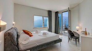 Una habitación de hotel moderna con una cama, un escritorio y un balcón con vistas.
