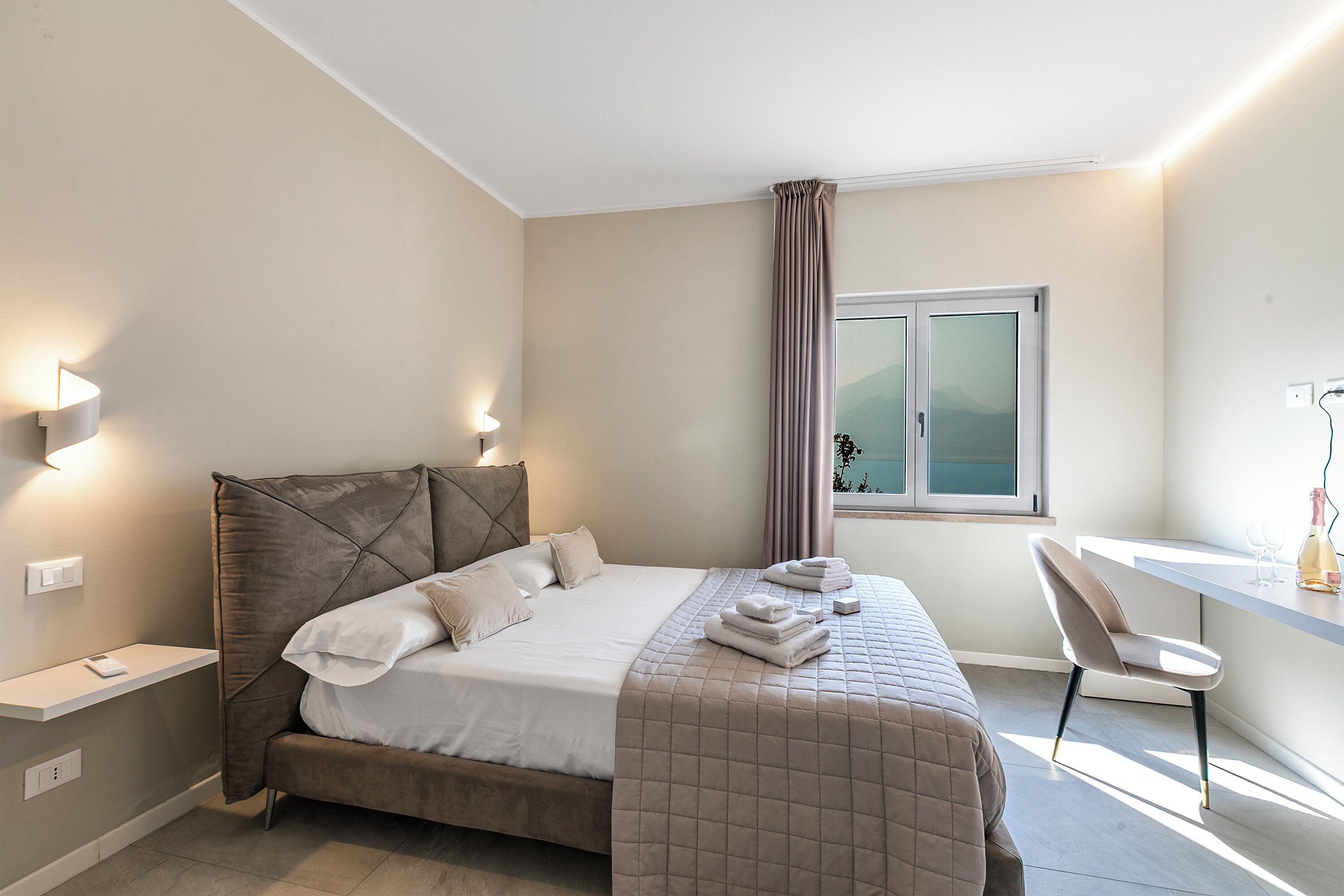 Ein modernes Schlafzimmer mit Bett, Nachttischen, Schreibtisch und Stuhl.