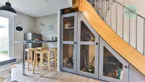 Une cuisine moderne avec un escalier en bois, des placards intégrés et un coin repas équipé de tabourets.