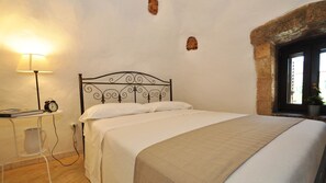 Ein Schlafzimmer mit Bett, Nachttisch mit Lampe und Fenster mit Blick.