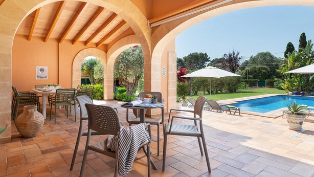 Una terrazza esterna con piscina, area lounge coperta e vista sulla piscina.