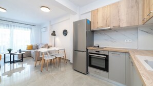 Una cocina moderna con horno empotrado, refrigerador y armarios de madera.
