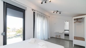 Habitación de hotel moderna con una cama grande, un baño con espejo y ducha, y vistas a la ciudad.
