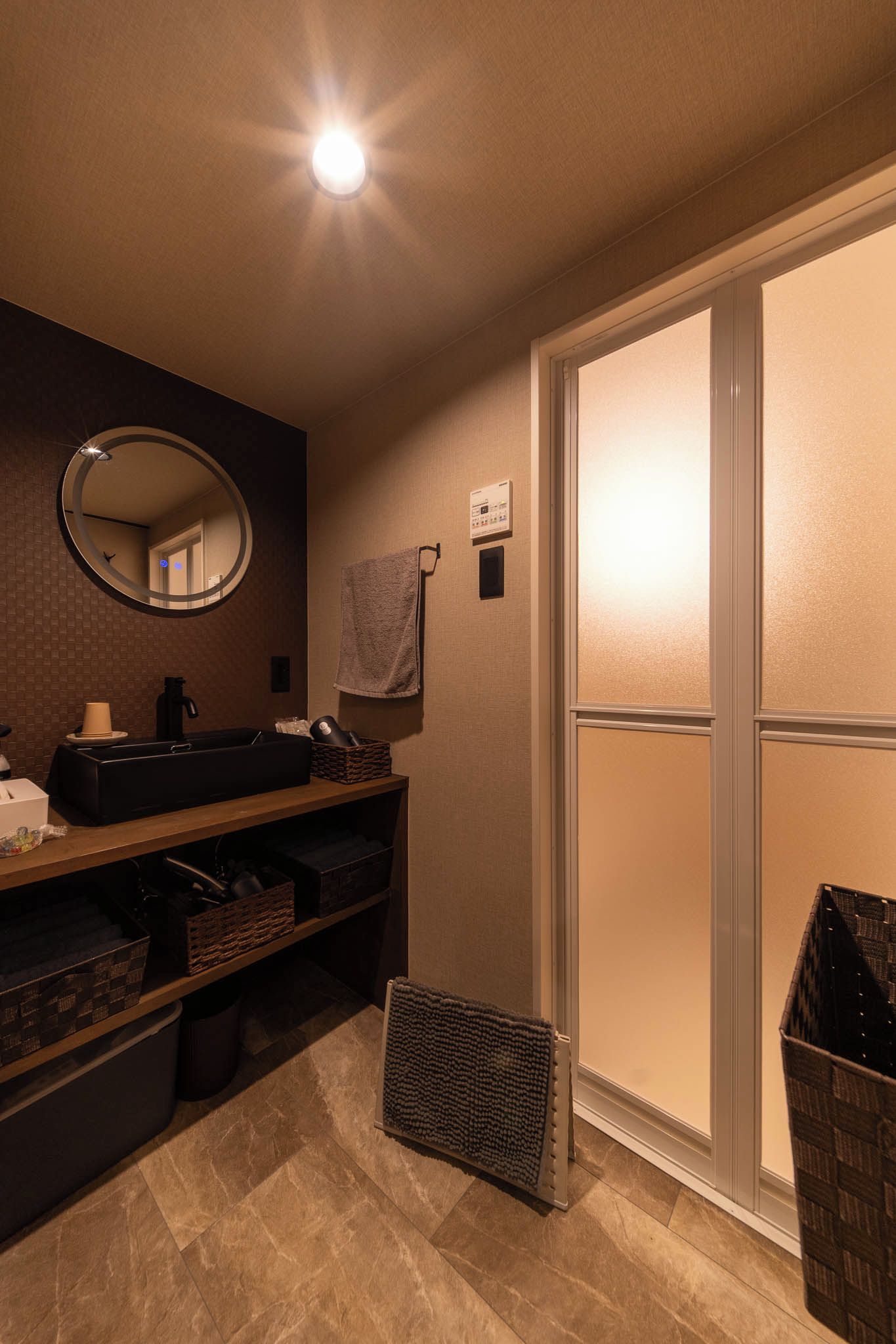 A bathroom with a sink, mirror, towel rack, and a sliding glass door.