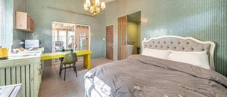A bedroom with a large bed, a desk, and a chair.