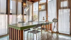 Een eethoek met een houten tafel, metalen stoelen en een klok op een statief.