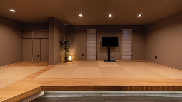 A room with tatami mats, a television, a plant, and a sliding door. - Oyado Kinokuniya Takaramachi (Nagasaki)