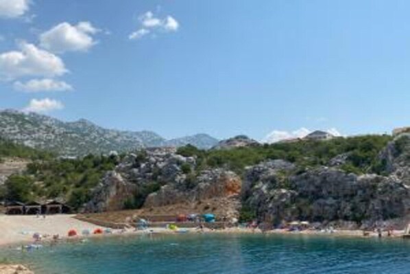 Une plage côtière avec un terrain rocheux et un ciel dégagé.