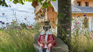 Et rustikt træhus med en dekorativ figur på en sten.