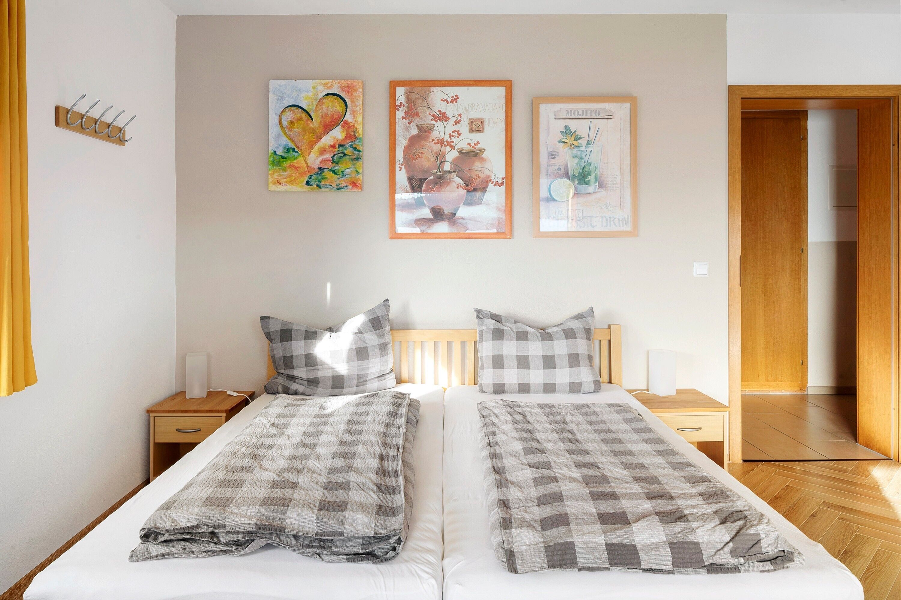 A double bed with checkered bedding, a wooden headboard, and two bedside tables with lamps.