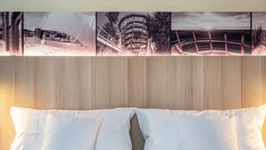 Een bed met witte kussens en een houten hoofdbord.