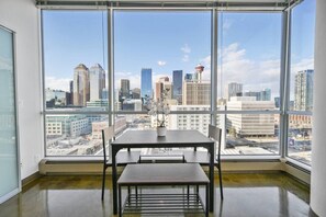 A room with a large window, a table, and chairs.