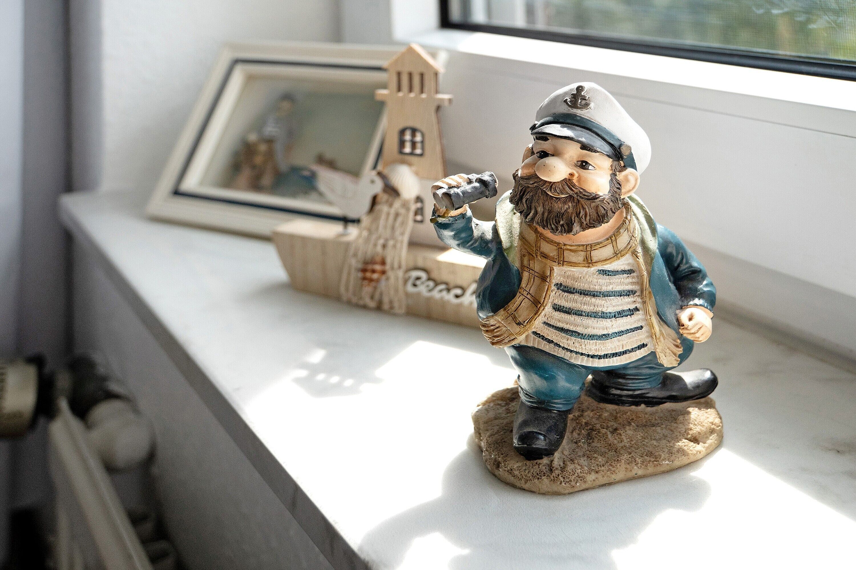 Eine Figur eines bärtigen Mannes in Seemannskleidung auf einem Regal.
