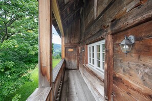 Eine Veranda aus Holz mit einem Fenster und einer Wandleuchte.