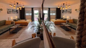 Habitación con espejo, dos camas, un sofá, una mesa de centro y una planta en maceta.