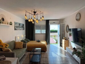 Estudio romántico, 1 cama doble, vistas al mar, junto a la piscina | Zona de estar | Televisión LED de 65 pulgadas con canales digitales