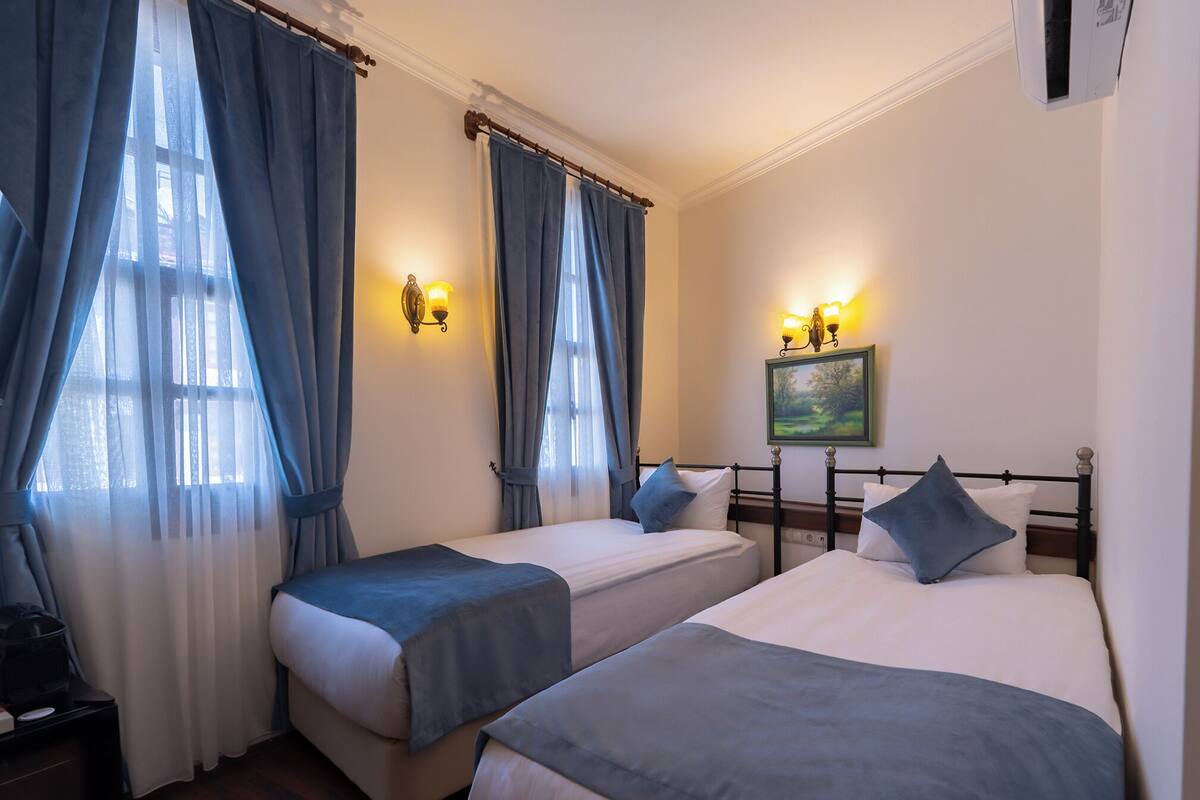 Ein Hotelzimmer mit zwei Betten, einem Nachttisch und einem Bild an der Wand.