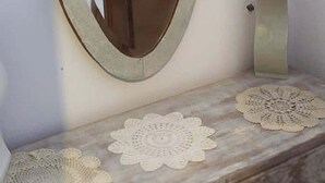 A mirror with a wooden frame on a dresser with a lace doily. - Sofia's house in Thiva (Thiva)