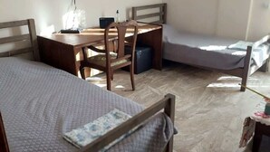 A small, compact room with two single beds, a wooden desk, and a chair. - Sofia's house in Thiva (Thiva)