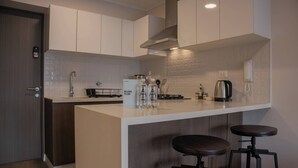 A modern kitchen with a central island, bar stools, and a built-in stove. - w* | Gorgeous 1BR w/ Terrace in Miraflores (Miraflores)