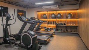 A gym with treadmills, an elliptical, and a wall with exercise equipment and weights. - w* | Gorgeous 1BR w/ Terrace in Miraflores (Miraflores)