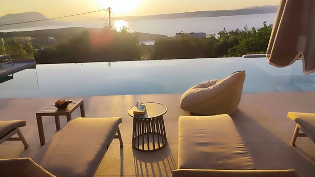A sunlit outdoor seating area with a view of the sea and mountains. - Brand new 2025,  villa Cactus by NiMaR villas, stunning seaviews infinity pool (kokkino chorio)