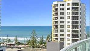 Ein Hochhaus mit mehreren Balkonen mit Blick auf einen Strand.