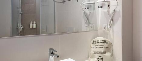 A bathroom with a sink, a mirror, a towel rack, and a hairdryer.