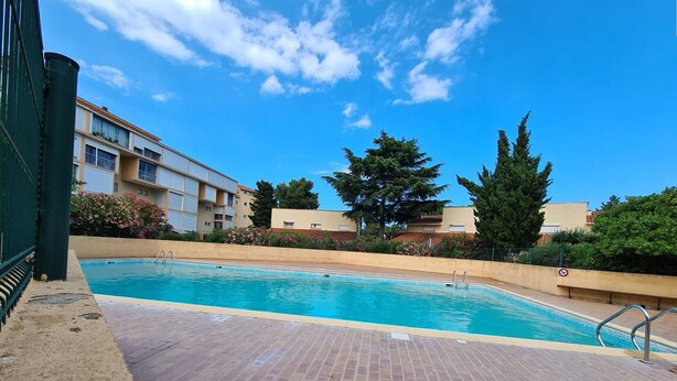 A swimming pool with a brick deck, surrounded by buildings and trees. - Cozy Studio with Pool Access, Private Garden, and Close to Beach - Argelès-sur-Mer (Argelès-sur-Mer)