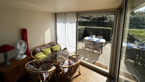 A balcony with wicker furniture, a glass table, and a fan. - Cozy Studio with Pool Access, Private Garden, and Close to Beach - Argelès-sur-Mer (Argelès-sur-Mer)
