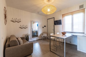 Relax in a spacious living area with a comfortable sofa set, dining table, and large mirror.