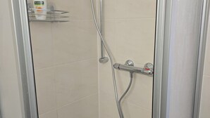 Une douche équipée d’un pommeau de douche et d’un flexible à main.