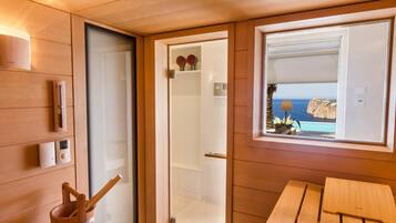 Enjoy a room with a door leading to another space, a small table and bench, and a window overlooking the sea.