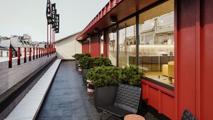 A rooftop terrace with a seating area, potted plants, and a view of the cityscape. - Bob W Helsinki Kamppi (Helsinki)